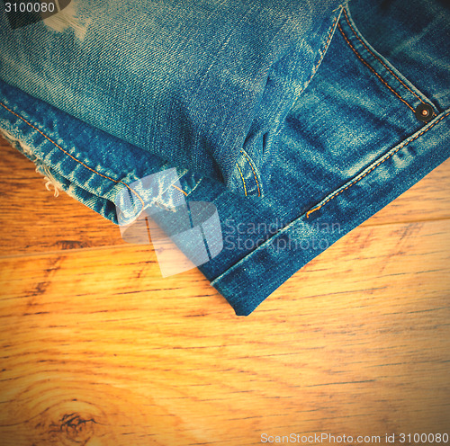 Image of blue jeans on the wooden shelf