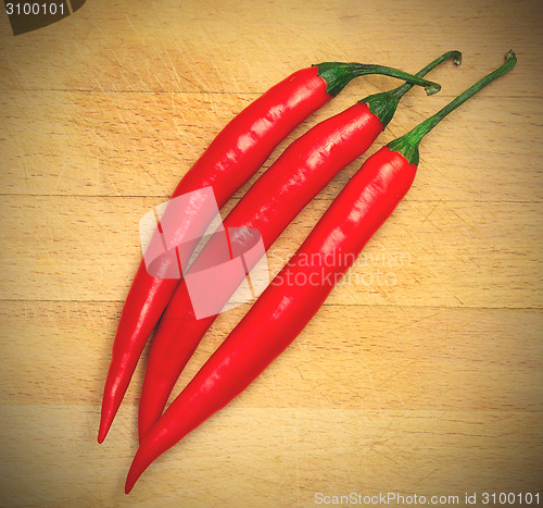 Image of peppers on the wooden background