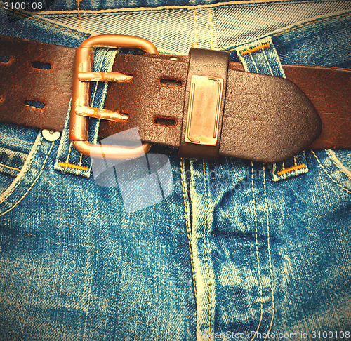 Image of leather belt on old jeans