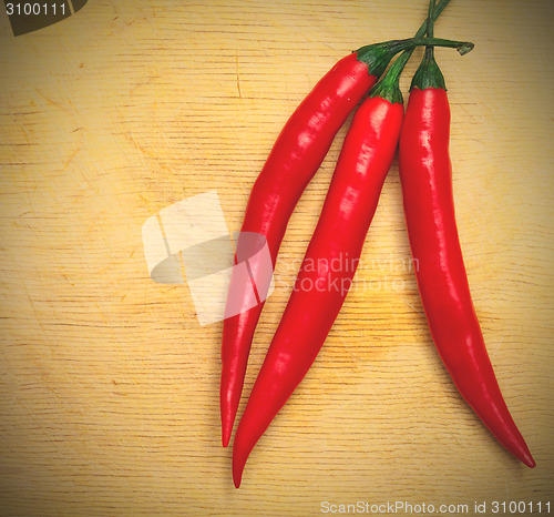 Image of three red hot chili peppers