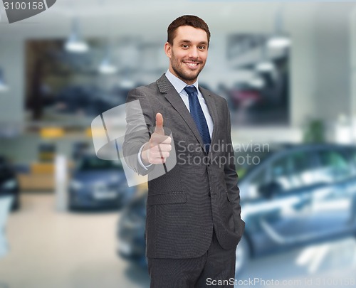 Image of smiling businessman showing thumbs up