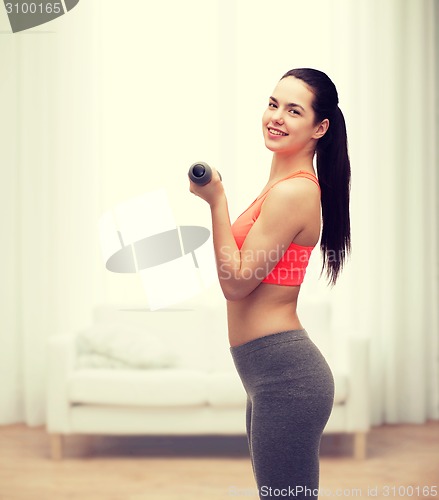 Image of young sporty woman with light dumbbells