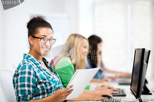 Image of african student with computer studying at school