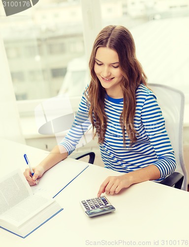 Image of student girl with book, calculator and notebook