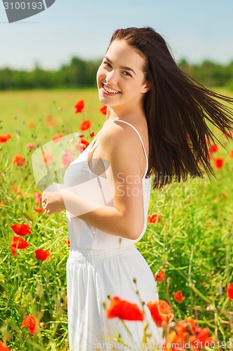 Image of smiling young woman on poppy field