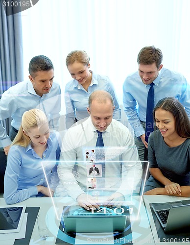 Image of smiling business people with laptop in office