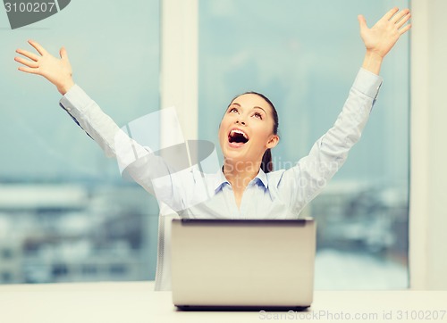 Image of screaming businesswoman with laptop in office