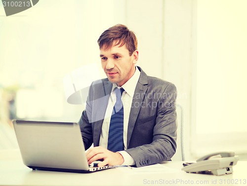 Image of businessman with laptop computer and documents