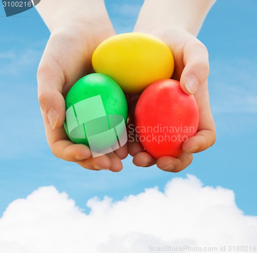 Image of close up of kid hands holding colored eggs