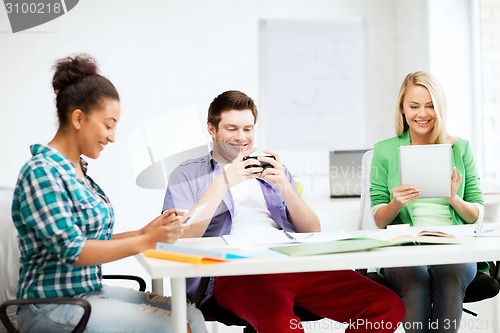 Image of students looking into devices at school