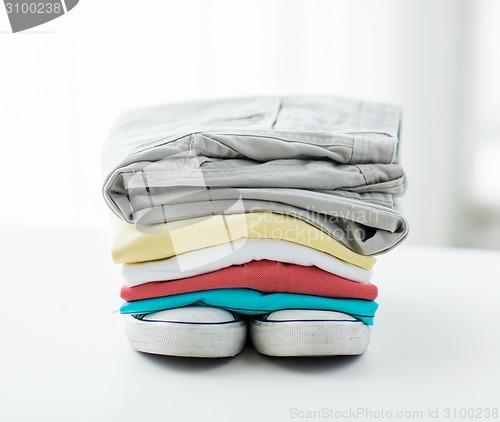 Image of close up of folded shirts and boots on table