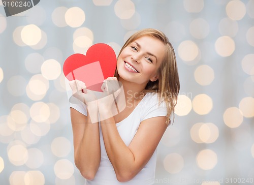 Image of smiling woman in white t-shirt holding red heart