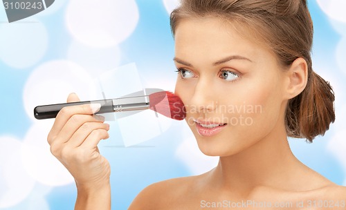 Image of beautiful smiling woman with make up brush