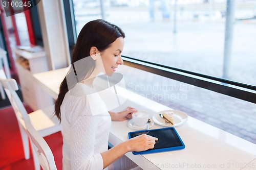 Image of smiling woman with tablet pc and coffee at cafe