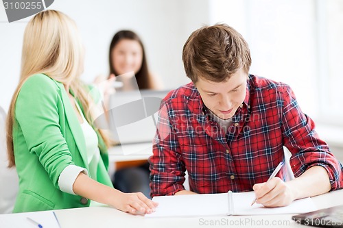 Image of students writing something at school