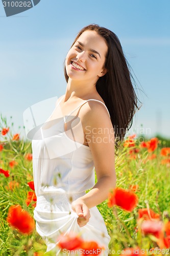 Image of smiling young woman on poppy field