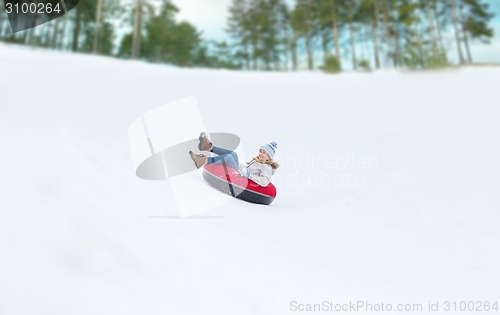 Image of happy teenage girl sliding down on snow tube