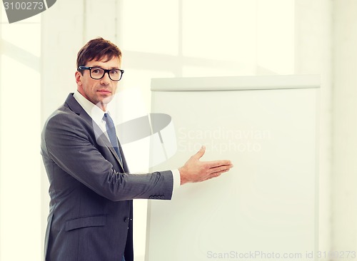 Image of businessman pointing to flip board in office