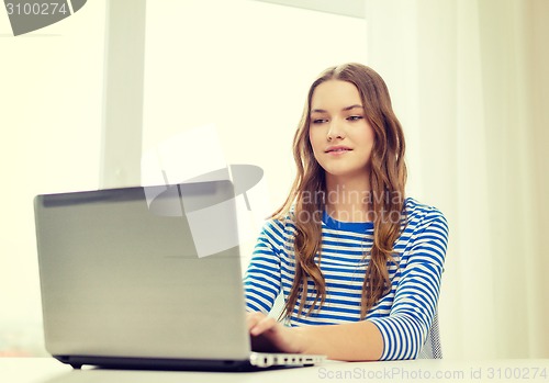 Image of smiling teenage gitl with laptop computer at home