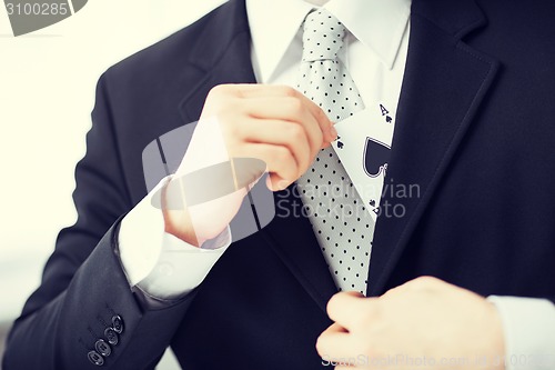 Image of mans hand hiding ace in the jacket pocket