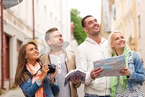 Image of group of friends with city guide, map and camera