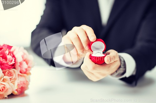 Image of man with gift box and wedding ring