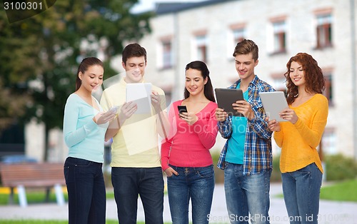 Image of group of teenagers with smartphones and tablet pc