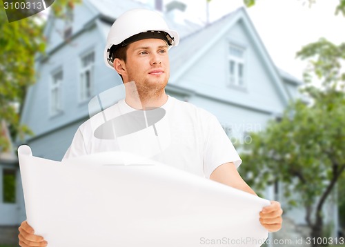 Image of male builder or architect in helmet with blueprint