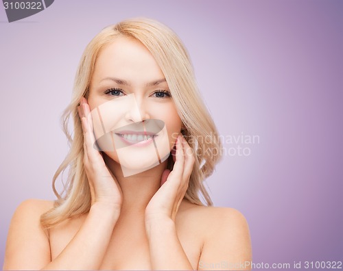 Image of beautiful young woman touching her face