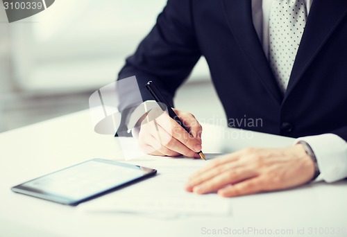 Image of man with tablet pc signing paper