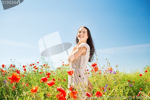 Image of smiling young woman on poppy field