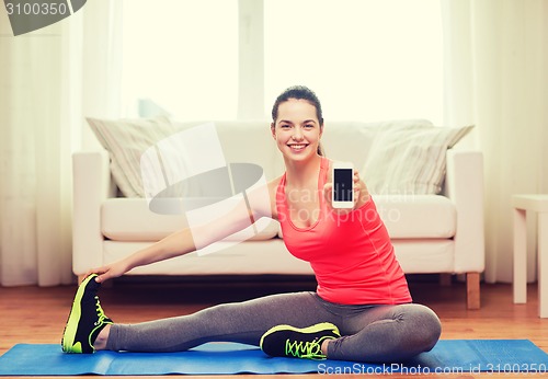 Image of smiling teenage girl streching on floor at home