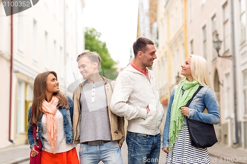 Image of group of smiling friends walking in the city