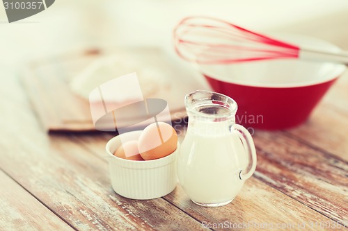 Image of jugful of milk, eggs in a bowl and flour