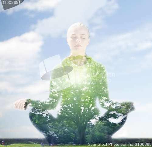 Image of happy young woman doing yoga outdoors