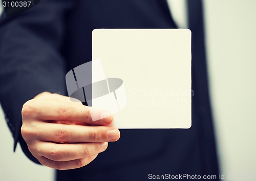 Image of man in suit holding blank card