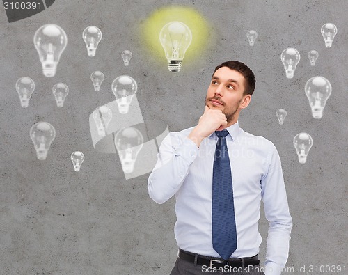 Image of handsome businessman looking up and thinking