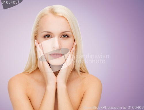 Image of beautiful young woman touching her face