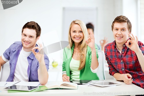 Image of students with tablet pcs showing ok sign