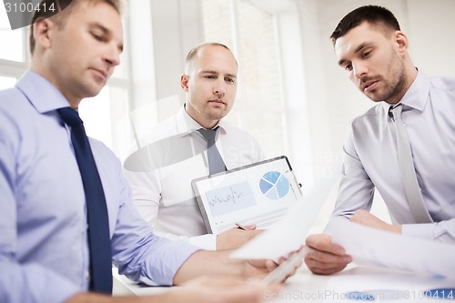 Image of serious businessmen with papers in office