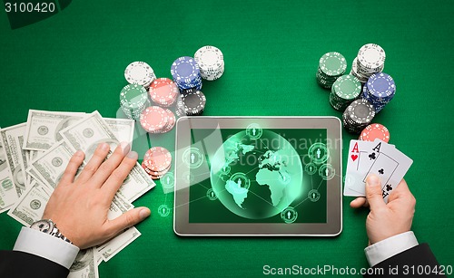 Image of casino poker player with cards, tablet and chips