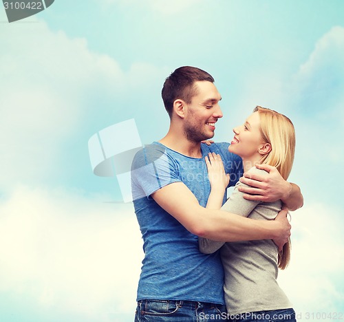 Image of smiling couple hugging and looking at each other