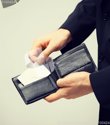 Image of man in suit holding credit card