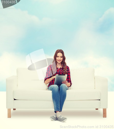 Image of teenage girl sitting on sofa with tablet pc