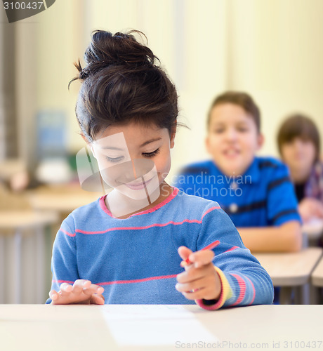 Image of happy little school girl over classroom background