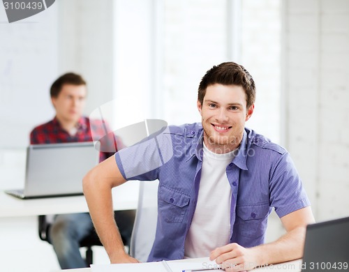 Image of smiling student with laptop at school