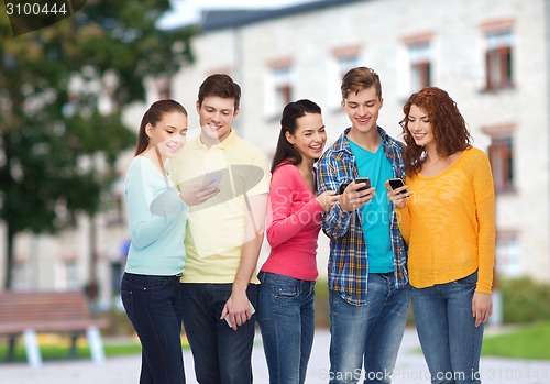 Image of group of smiling teenagers with smartphones