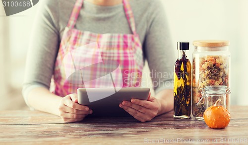 Image of closeup of woman reading recipe from tablet pc