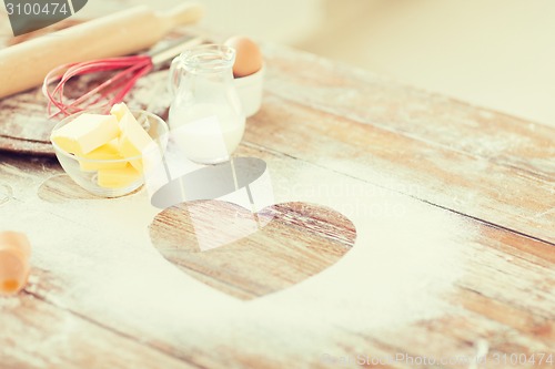 Image of close up of heart of flour on wooden table at home