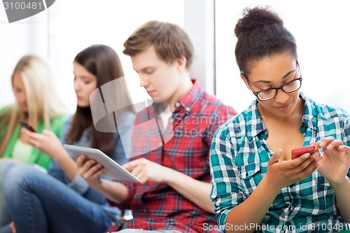 Image of students looking into devices at school